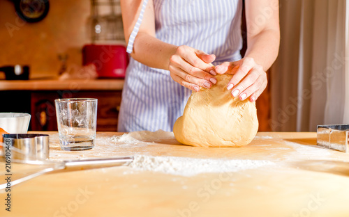 Making dough by female hands on wooden table