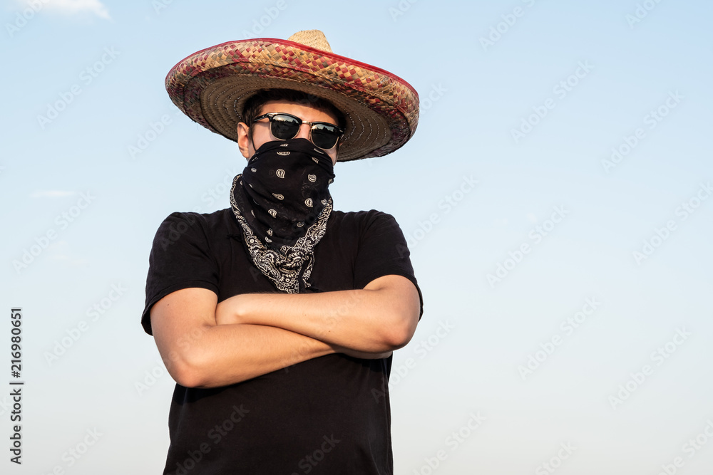 Young male person dressed up as gangster in traditional sombrero, bandana.  Mexican festive or halloween concept of man posing as bandit or western  style bandit Photos | Adobe Stock