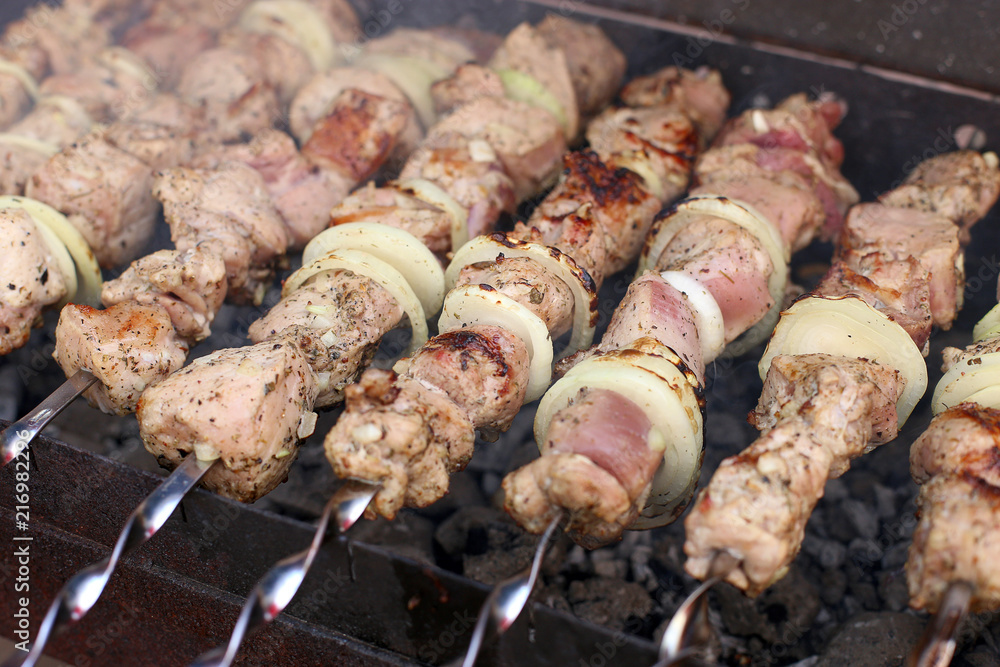 Barbecue in nature in summer. Pork meat in the smoke on the coals, healthy food, closeup.