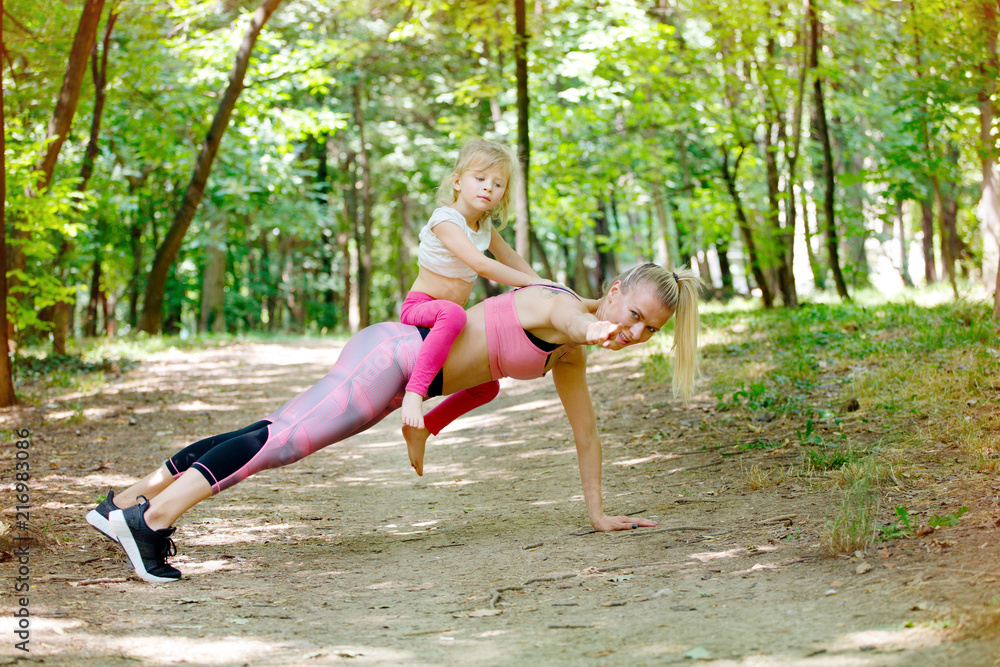 Fototapeta premium Mother and young daughter doing push ups together. Sport, Woman, Exercising, Child, Family, 