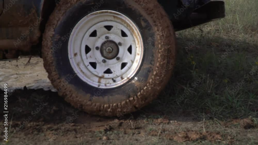 Extreme conditions for driving. Powerful tow SUV on dirty rural road after rain in bad weather. Dirty car in a brown dirty puddle. Off-road. Extreme conditions for driving. Powerful tow SUV on dirty rural road after rain in bad weather. Dirty car in a brown dirty puddle. Off-road.