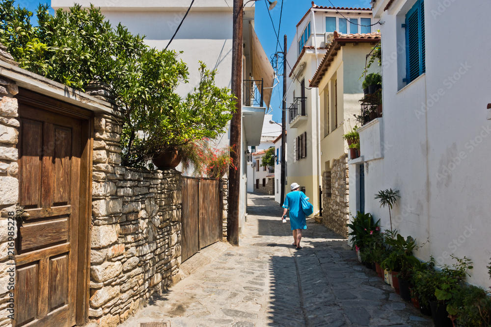 Walking at narrow winding streets at the old town of Skiathos, island of Skiathos, Greece