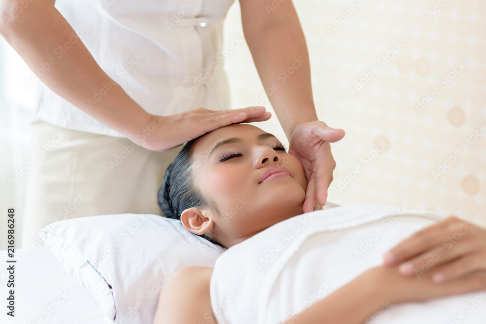 Young asian woman enjoying face massage in luxurious beauty salon. Young asian woman enjoying face massage in luxurious beauty salon.