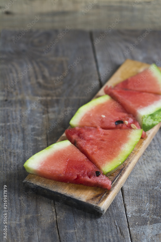 Several pieces of ripe watermelon on a wooden surface.
