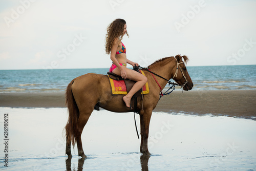Pretty young lady riding a horse on the beach background of the sea © ic36006