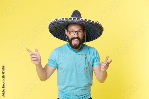 Celebrate traditions. Man on smiling face in sombrero hat celebrating, yellow background. Guy with beard looks festive in sombrero. Fest and holiday concept. Man in festive mood at party celebrating