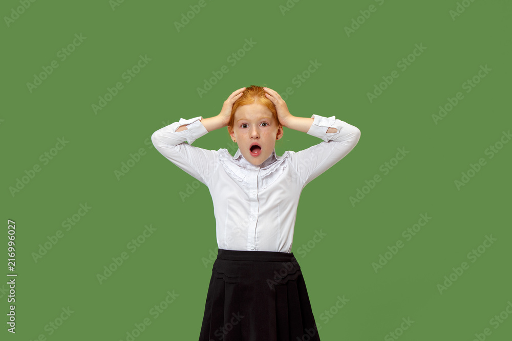 Wow. Beautiful female half-length front portrait isolated on green studio backgroud. Young emotional surprised teen girl standing with open mouth. Human emotions, facial expression concept. Trendy Wow. Beautiful female half-length front portrait isolated on green studio backgroud. Young emotional surprised teen girl standing with open mouth. Human emotions, facial expression concept. Trendy