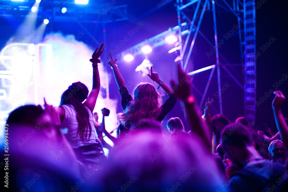 Obraz premium cheering crowd with raised hands at concert - music festival