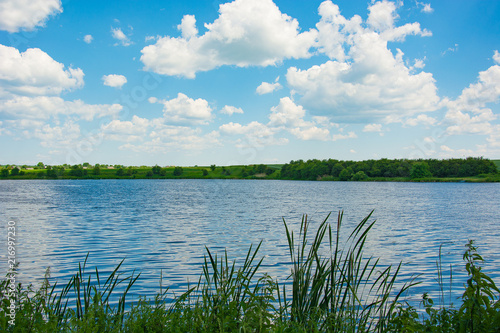 Beautiful blue sky with clouds above the lake photo