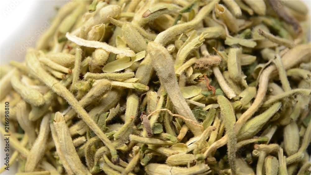 Chinese herb medicine of Lonicerae Japonicae Flos or Japanese Honysuckle Flower Bud rotating close up Chinese herb medicine of Lonicerae Japonicae Flos or Japanese Honysuckle Flower Bud rotating close up