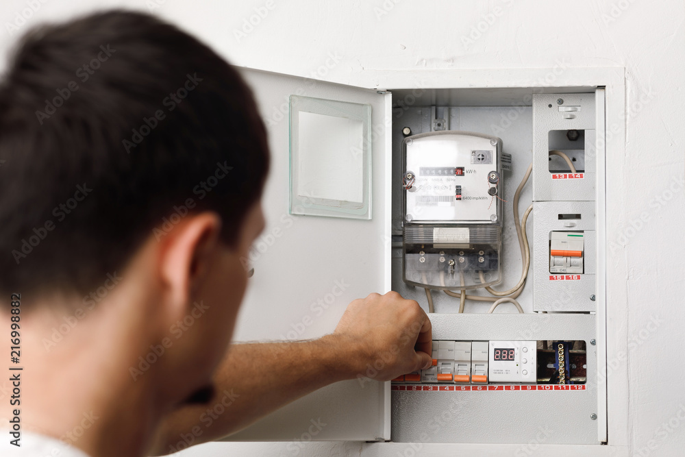 Electrical terminal box. man turn on or off Stock Photo | Adobe Stock