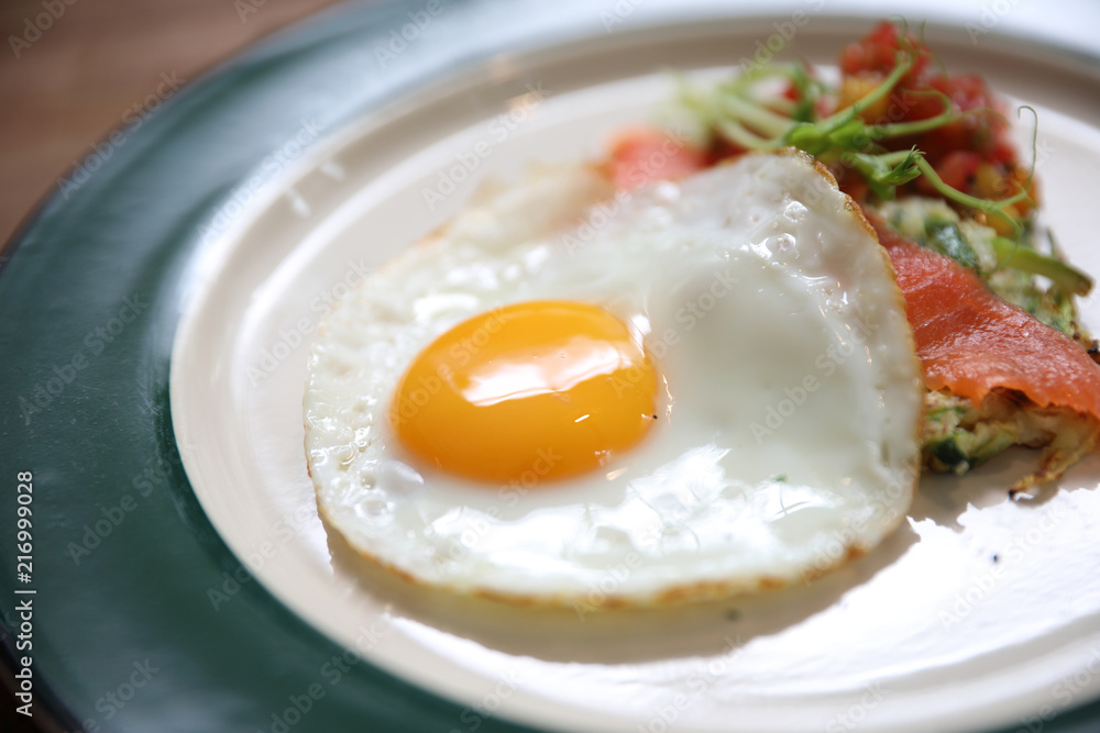 Zucchini fritters with egg and smoked salmon on wood background vinage style Zucchini fritters with egg and smoked salmon on wood background vinage style