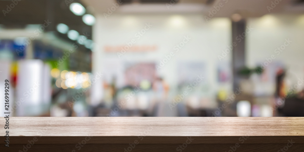 Empty wooden table top with blurred store background.