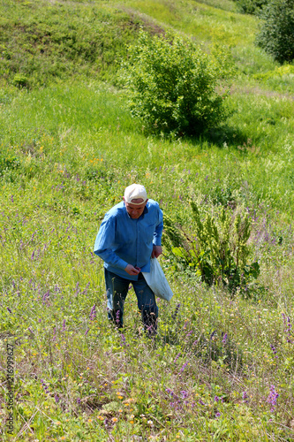 man walking on the mountainside on the green grass