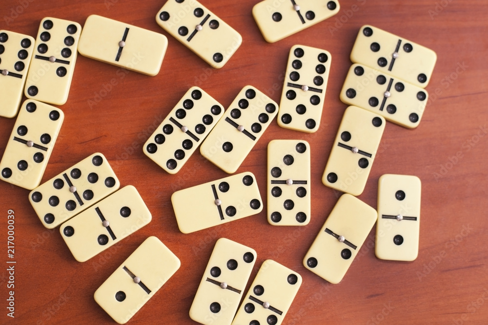 Domino's board game is chaotic on a wooden background Domino's board game is chaotic on a wooden background