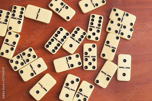 Domino s board game is chaotic on a wooden background