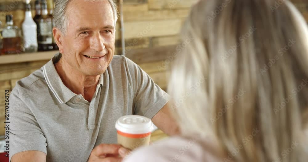 Man at cafe counter serving coffee to a woman 4k