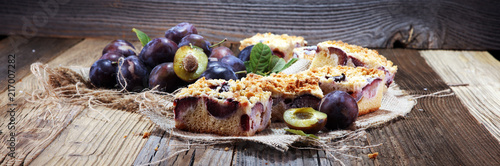 Wallpaper Mural Rustic plum cake on wooden background with plums around.