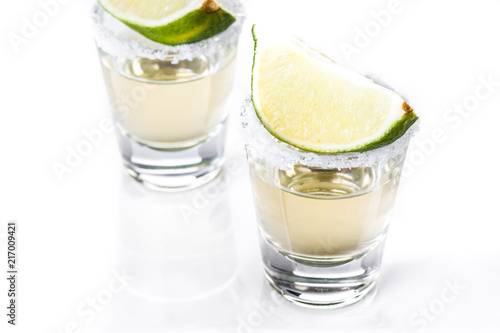 Mexican Gold tequila with lime and salt isolated on white background

