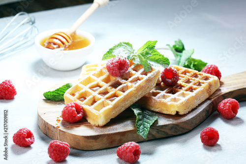 Traditional belgian waffles with fresh mint, sugar and raspberries.