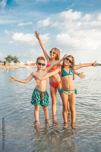Happy children spreading hands on the beach