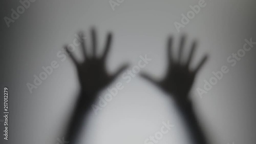 Shadowy figure behind glass / fear, panic concept