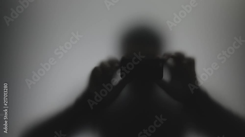 Anonymous shadow stalker shooting video on phone