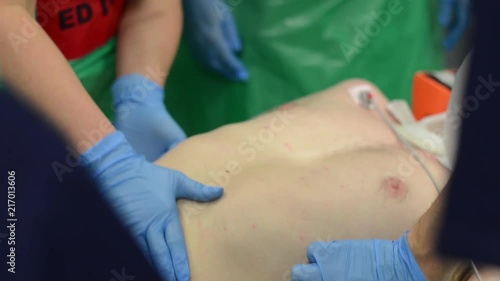 Nurse checks and touches the patient's abdomen with his hands.