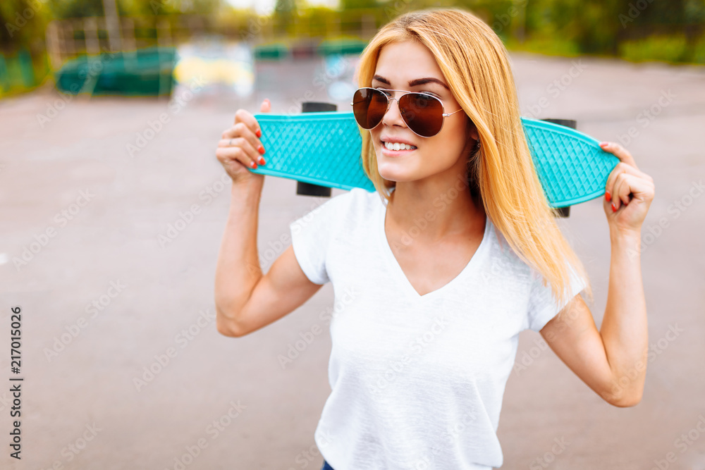portrait of a beautiful girl, with a skate, in a skate Park, summer day