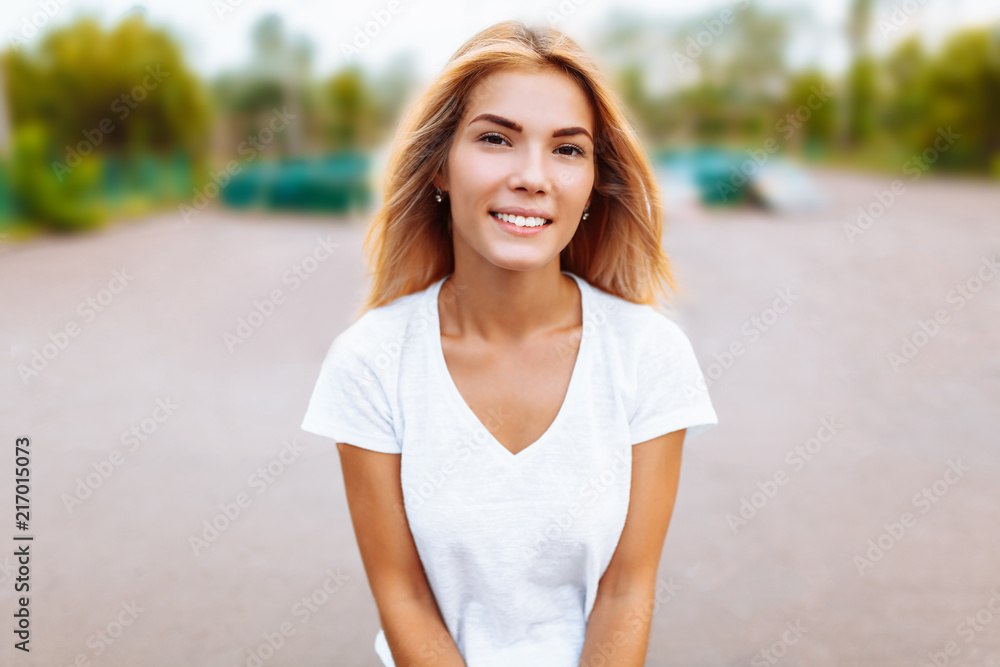 Portrait of a beautiful girl close-up, in the Park, cheerful and cute, in a white t-shirt Portrait of a beautiful girl close-up, in the Park, cheerful and cute, in a white t-shirt