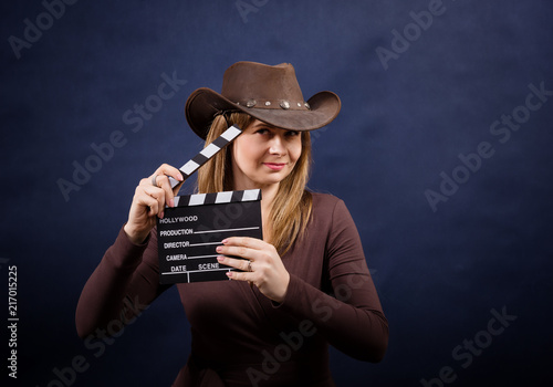 Young woman with clapperboard in cowboy hat. Movie lover photo