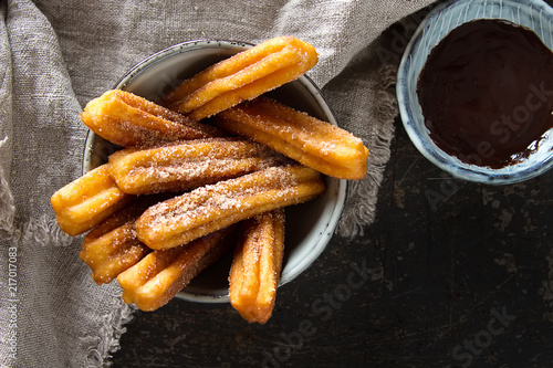 Traditional Mexican dessert churros with chocolate sauce. Dark background photo