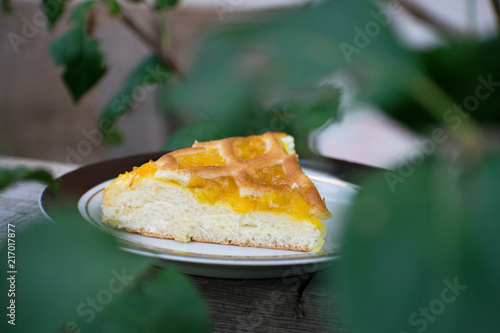 Delicious cake with apricot jam on a plate. Crostata with marmalade or peach jam filling. Homemadepie dessert with dandelion jam.
