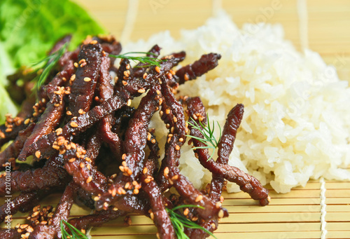 Deep Fried Marinated Beef (Thai name is Nuer Dad Diew)  with sticky rice on bamboo tray.Beef Thai style menu for food preservation with Sun Dried.