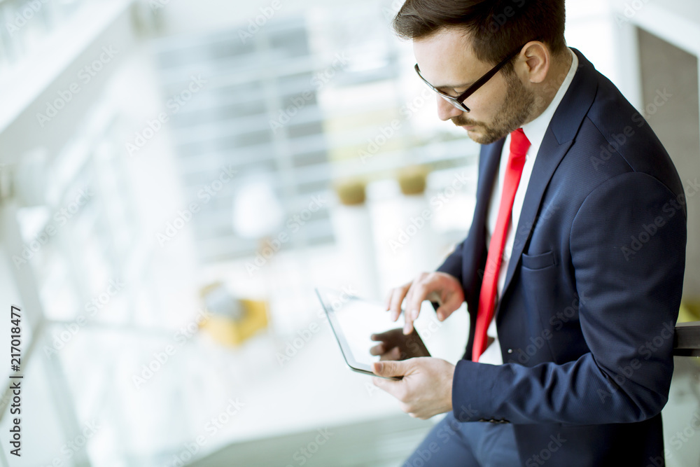 Young man with tablet on stairs in modern office Young man with tablet on stairs in modern office