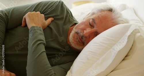 Senior man sleeping on bed in bedroom 4k photo