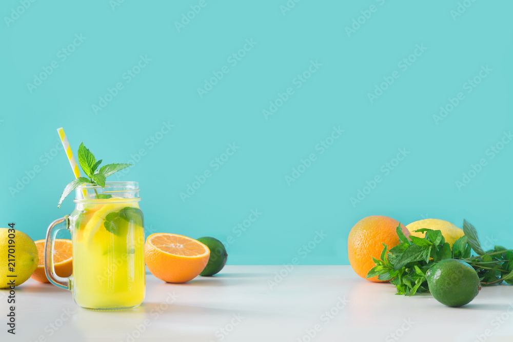 Fototapeta premium Lemonade in mason jar with lemon and mint on blue. Copy space.
