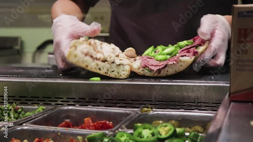 Making sandwich in a deli with fresh meats and vegetables. photo