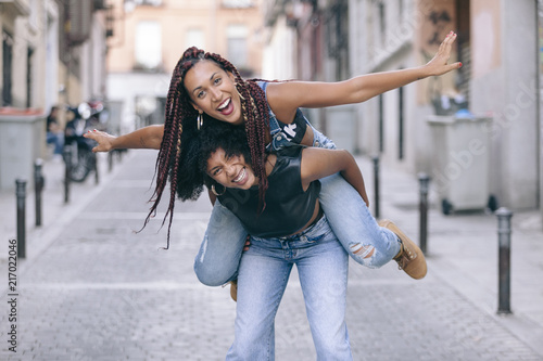 cheerful women playing with freedom at the street
