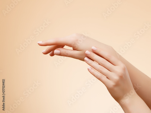 Closeup image of beautiful woman s hands with light pink manicure on the nails. Skin care for hands  manicure and beauty treatment. Elegant and graceful hands with slender graceful fingers