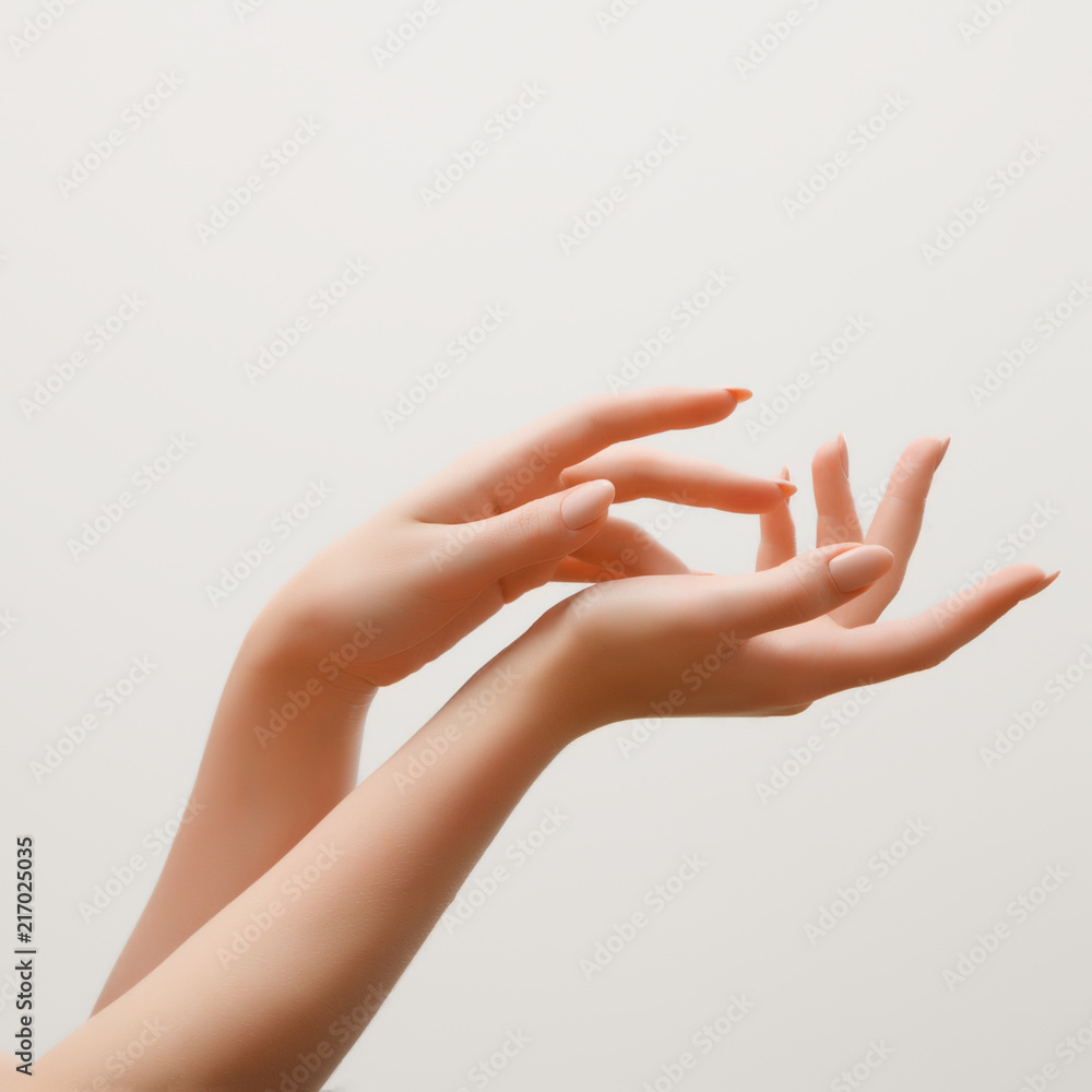 Closeup image of beautiful woman's hands with light pink manicure on the  nails. Skin care for hands, manicure and beauty treatment. Elegant and  graceful hands with slender graceful fingers Stock Photo