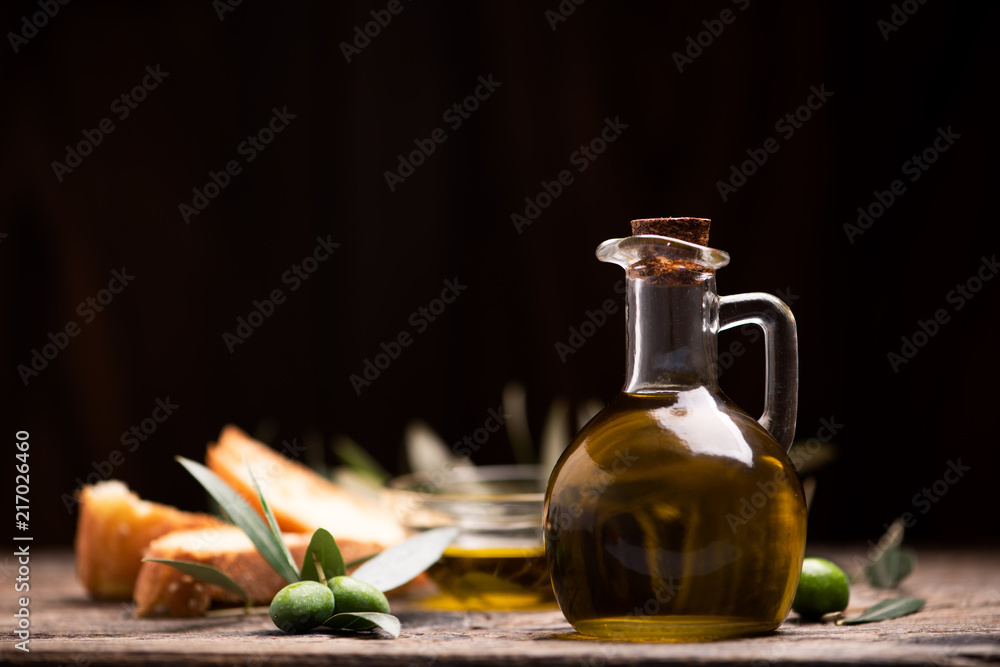 Olive oil with bread on a wooden table. Olive oil with bread on a wooden table.
