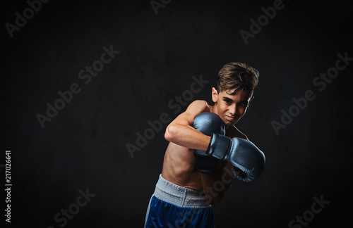 Handsome shirtless young boxer during boxing exercises, focused on process with serious concentrated facial. © Fxquadro
