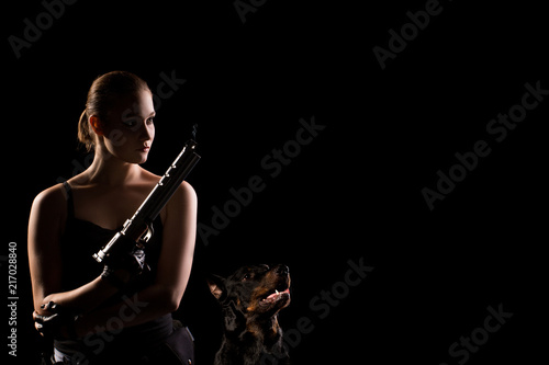 Military woman with a sport gun over black background