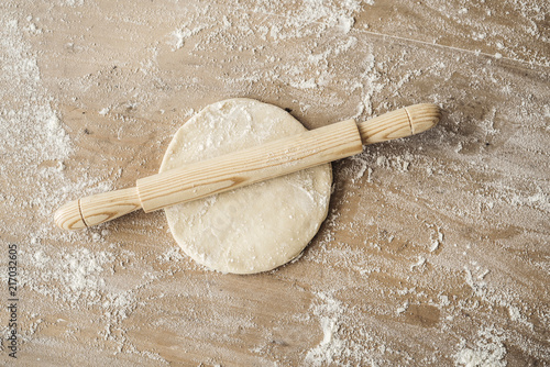 Dough flour and rolling pin on wooden table photo