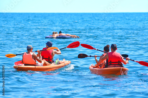 A group of kayaks are swimming by the sea. Kayaking background...