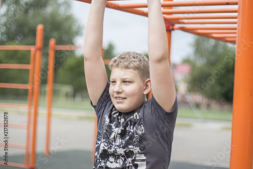 a boy with blond hair is engaged in the Playground
