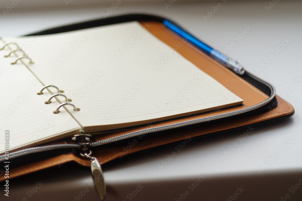 Undated diary on rings with blue pen on white background. Undated diary on rings with blue pen on white background.
