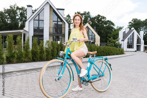 Bike ride. Beautiful nice woman smiling to you while preparing to ride a bike