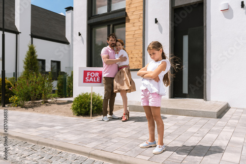 I do not want to move. Nice cute girl standing cross handed while not wanting to move to a new house